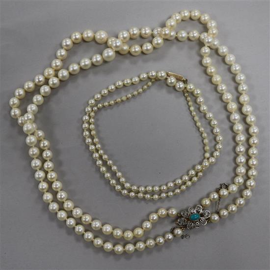 A double strand graduated cultured pearl necklace with gem set yellow metal clasp and a single strand cultured pearl necklace.